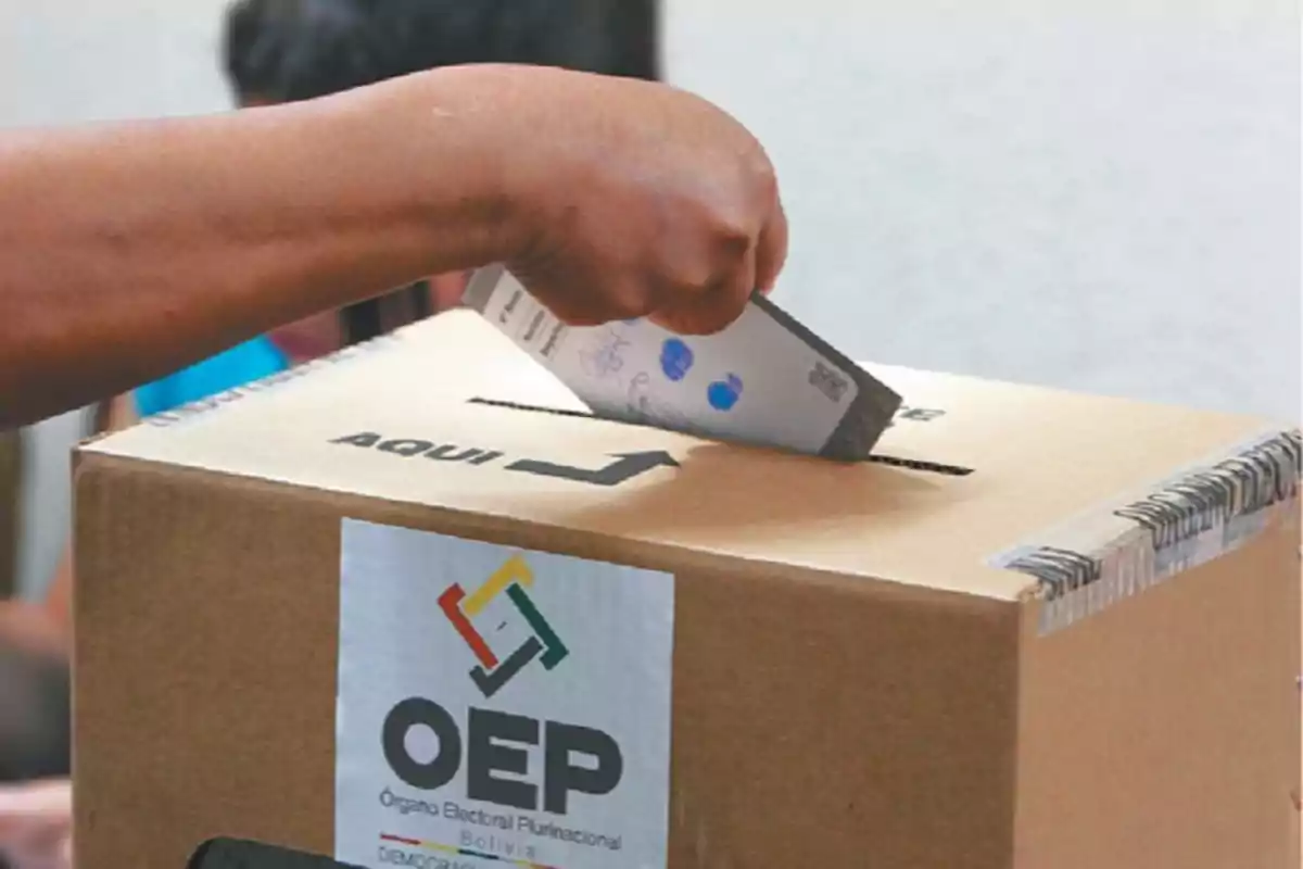 Person casting a ballot into an election box in Bolivia Person casting a ballot into an election box in Bolivia