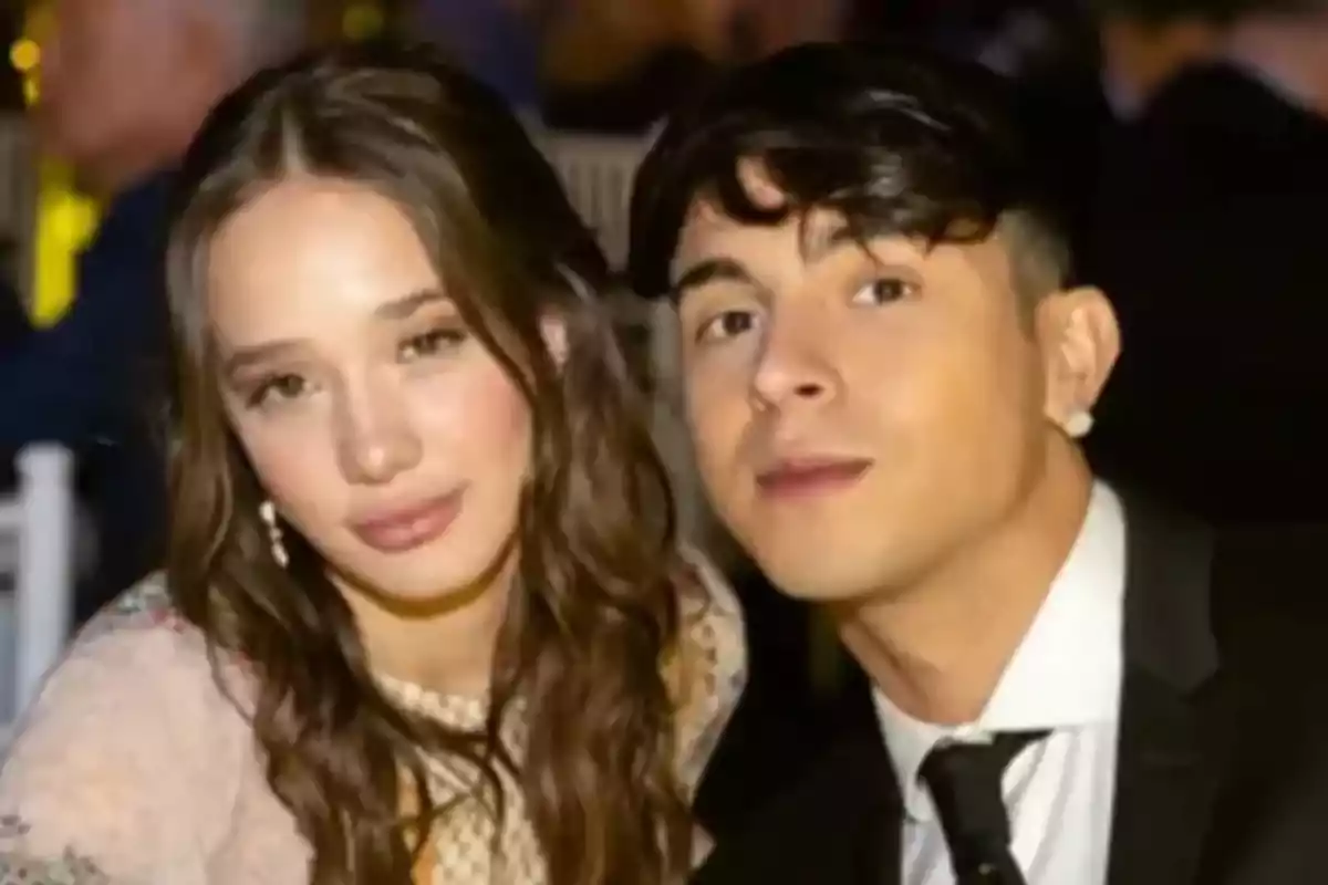 A young couple poses for a photo at a fancy event. A young couple poses for a photo at a fancy event.