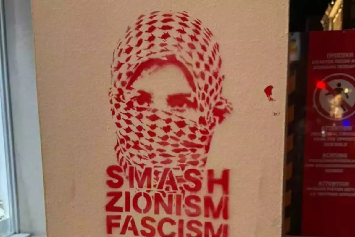 Painting on a wall showing the face of a person with a headscarf and the message in English "Smash Zionism Fascism" in red letters