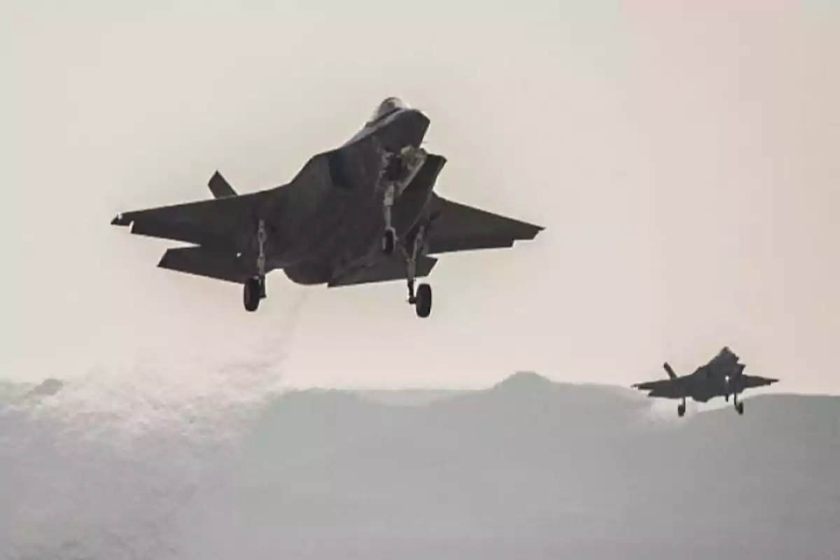 Dos aviones de combate despegando en un entorno desértico con el tren de aterrizaje extendido