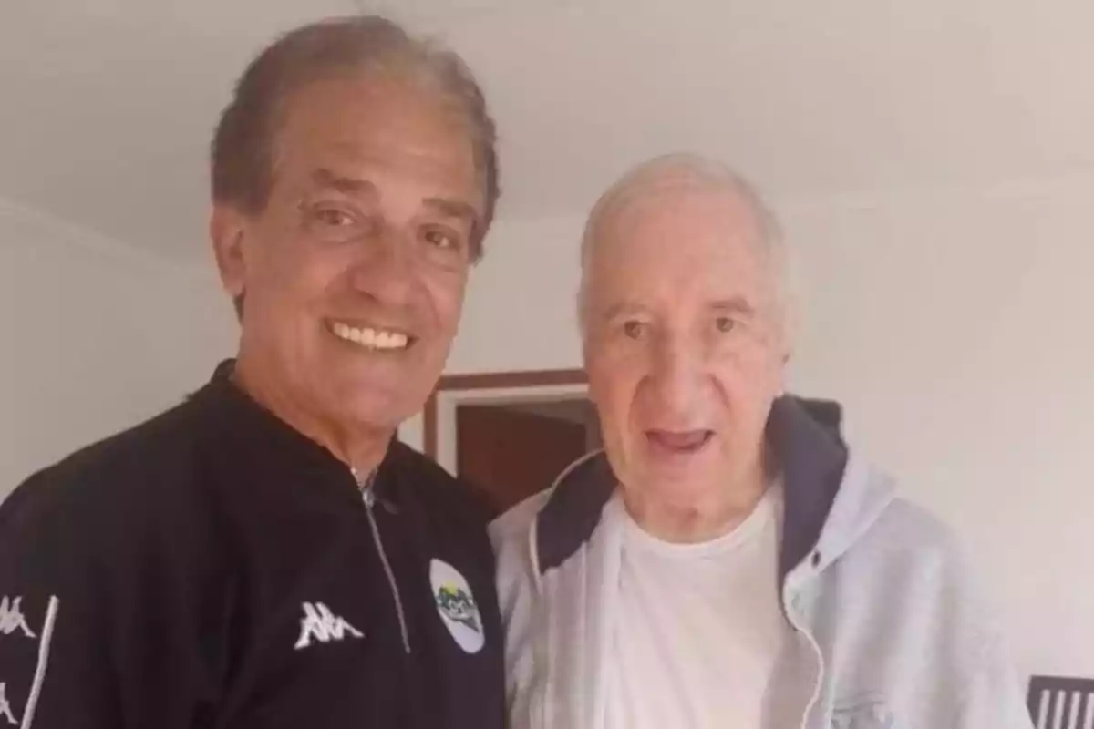 Dos hombres mayores sonríen juntos en una habitación iluminada