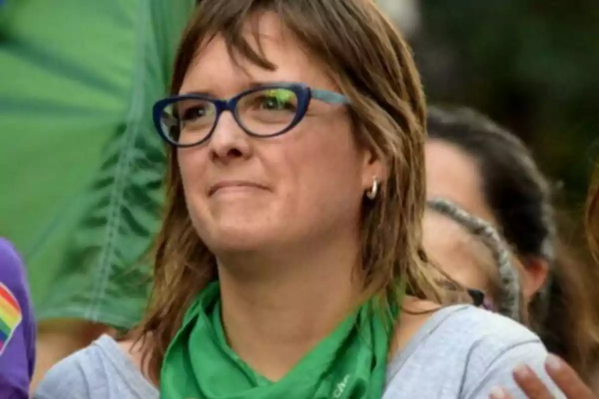 Mujer con gafas y pañuelo verde en el cuello participando en una manifestación Mujer con gafas y pañuelo verde en el cuello participando en una manifestación