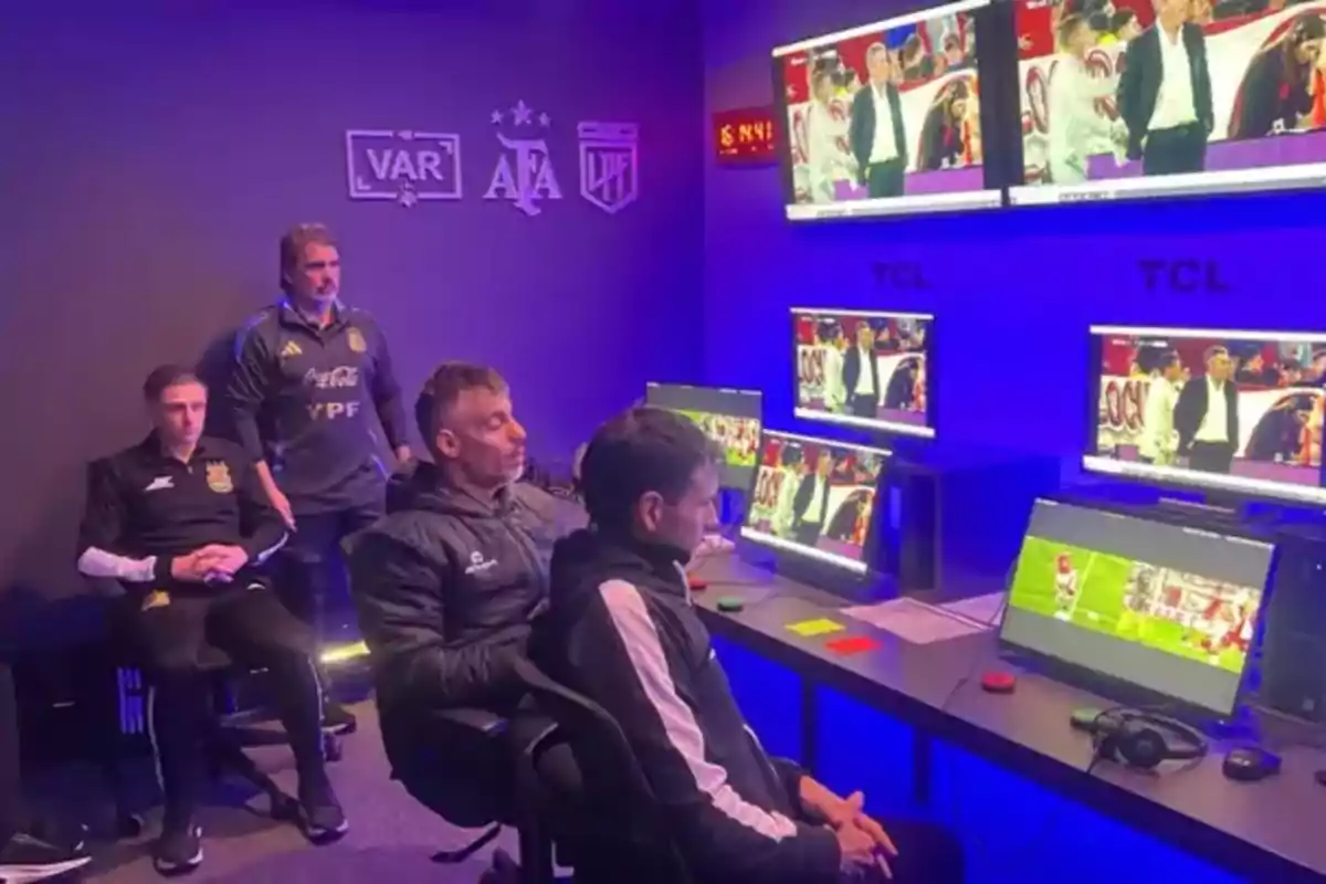 Football officials watch multiple screens in a VAR room during a match. Football officials watch multiple screens in a VAR room during a match.