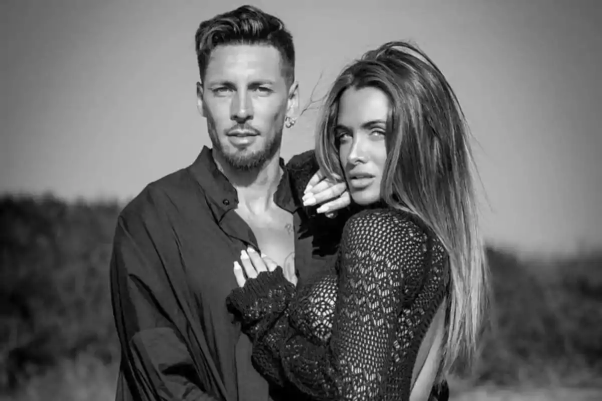 Pareja posando juntos al aire libre en una fotografía en blanco y negro Pareja posando juntos al aire libre en una fotografía en blanco y negro