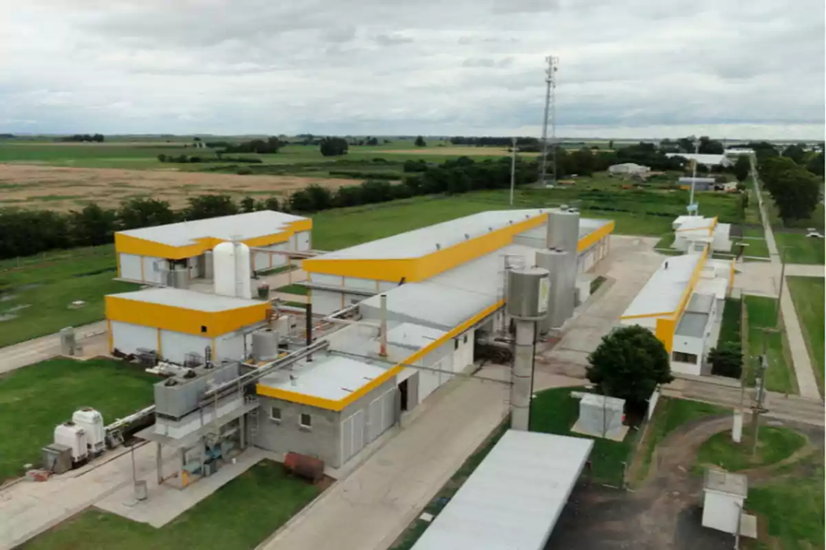 Vista aérea de una planta industrial rodeada de áreas verdes y campos abiertos Vista aérea de una planta industrial rodeada de áreas verdes y campos abiertos
