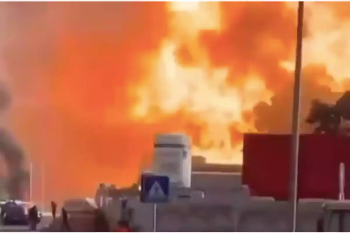 Large-scale fire in an urban area with visible flames and smoke in the background Large-scale fire in an urban area with visible flames and smoke in the background