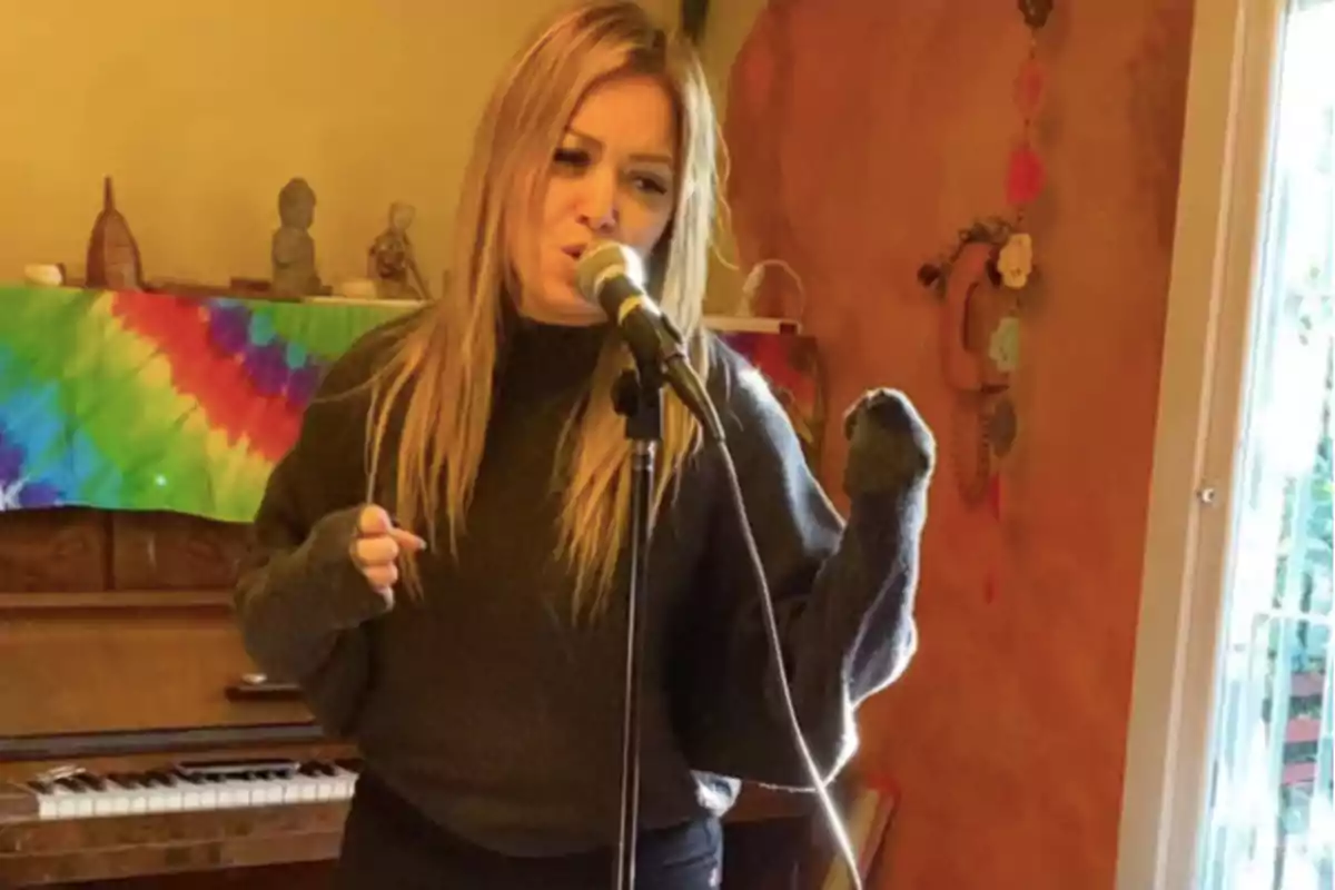 Woman singing in front of a microphone in a room with a piano and a colorful fabric in the background Woman singing in front of a microphone in a room with a piano and a colorful fabric in the background