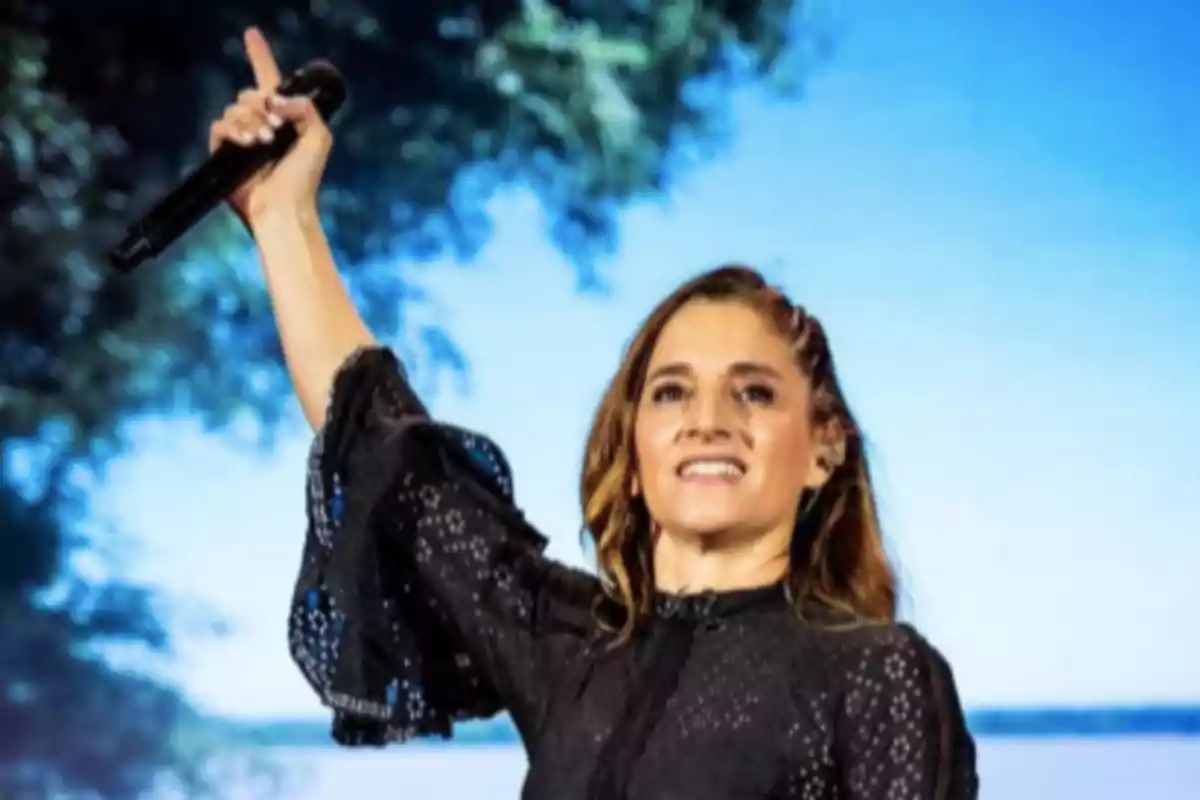 Smiling woman with a microphone in her raised hand during an outdoor presentation Smiling woman with a microphone in her raised hand during an outdoor presentation