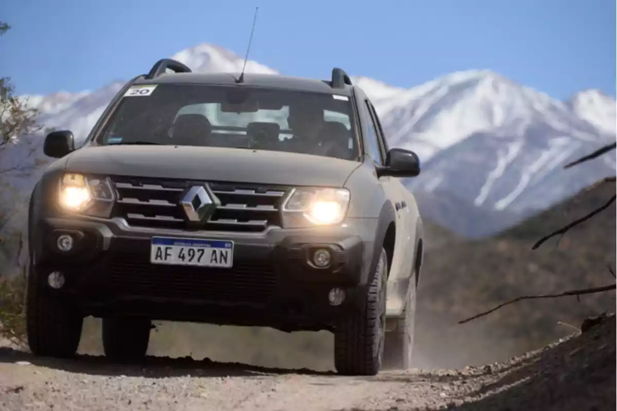 Renault Duster pickup driving on a dirt road with snow-capped mountains in the background Renault Duster pickup driving on a dirt road with snow-capped mountains in the background