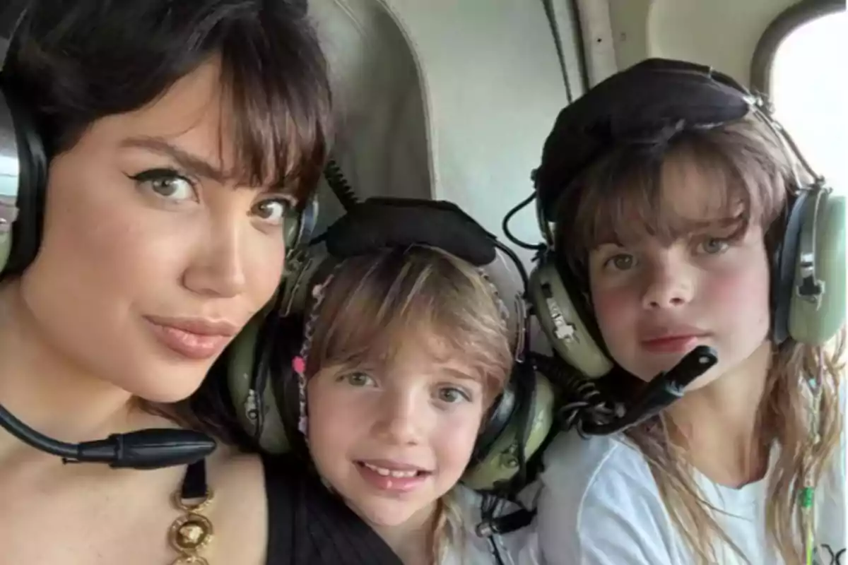 Tres personas usando auriculares de aviación dentro de una cabina de helicóptero Tres personas usando auriculares de aviación dentro de una cabina de helicóptero
