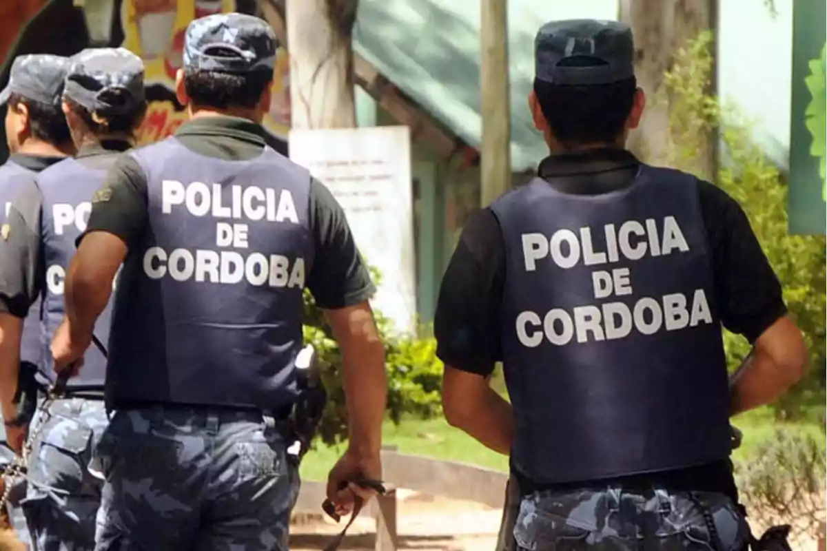 Varios agentes de la policía de Córdoba caminando al aire libre con chalecos y uniformes azules Varios agentes de la policía de Córdoba caminando al aire libre con chalecos y uniformes azules