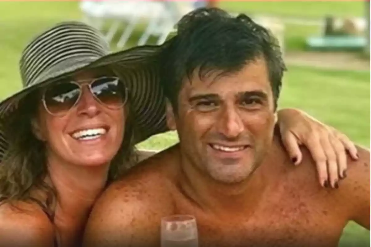 Smiling couple enjoying a sunny day outdoors, the woman is wearing a wide-brimmed hat and sunglasses Smiling couple enjoying a sunny day outdoors, the woman is wearing a wide-brimmed hat and sunglasses