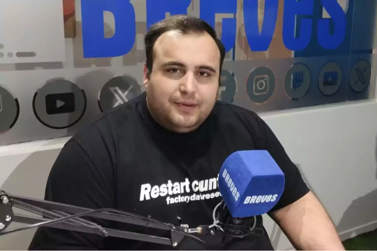Man sitting in front of a blue microphone with the word Man sitting in front of a blue microphone with the word