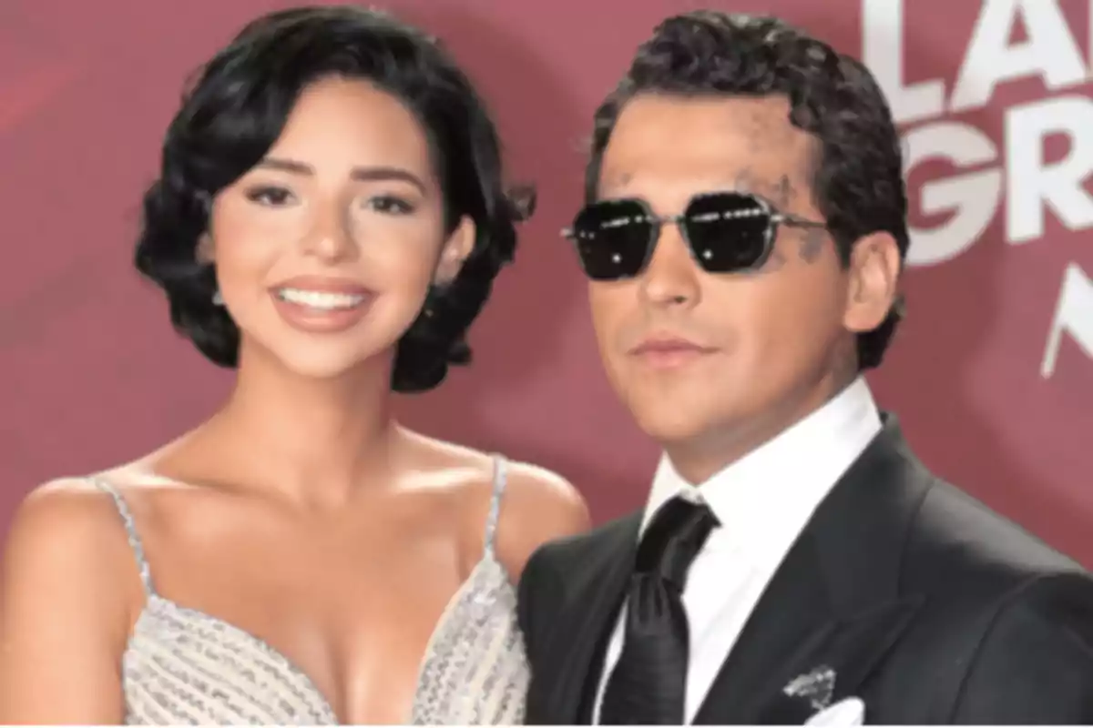 Una pareja posando en un evento formal con fondo rojo Una pareja posando en un evento formal con fondo rojo