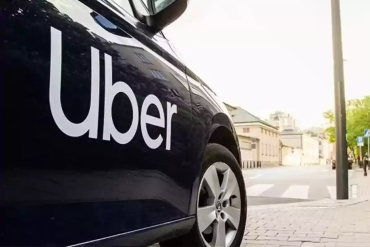 Auto negro con el logo de Uber estacionado en una calle urbana Auto negro con el logo de Uber estacionado en una calle urbana