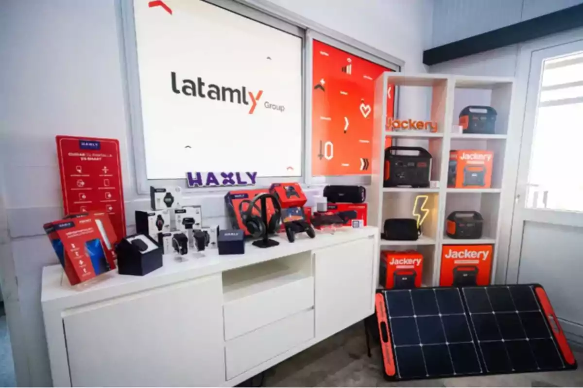Exhibition of electronic and technology products from the brands Haxly and Jackery in a room with white shelving, a portable solar panel, and various devices such as smartwatches, headphones, and portable batteries.