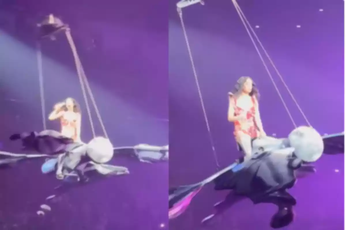 An artist in a red dress flies above the stage seated on a winged creature figure during a show with purple lights. An artist in a red dress flies above the stage seated on a winged creature figure during a show with purple lights.