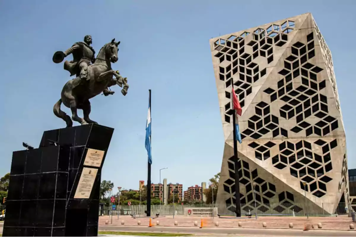 Equestrian sculpture in front of a modern building with geometric design in a city under a clear sky