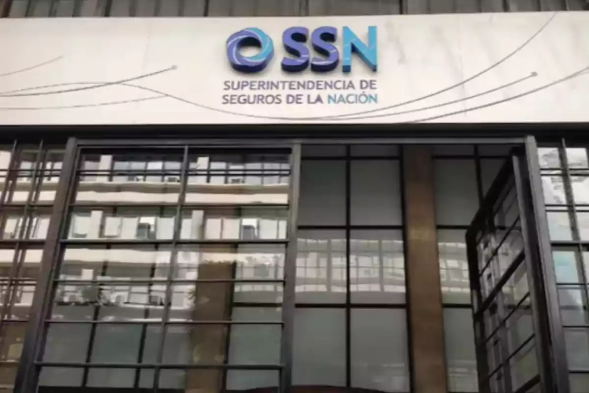 Fachada de un edificio con el cartel de la Superintendencia de Seguros de la Nación y puertas de vidrio abiertas Fachada de un edificio con el cartel de la Superintendencia de Seguros de la Nación y puertas de vidrio abiertas