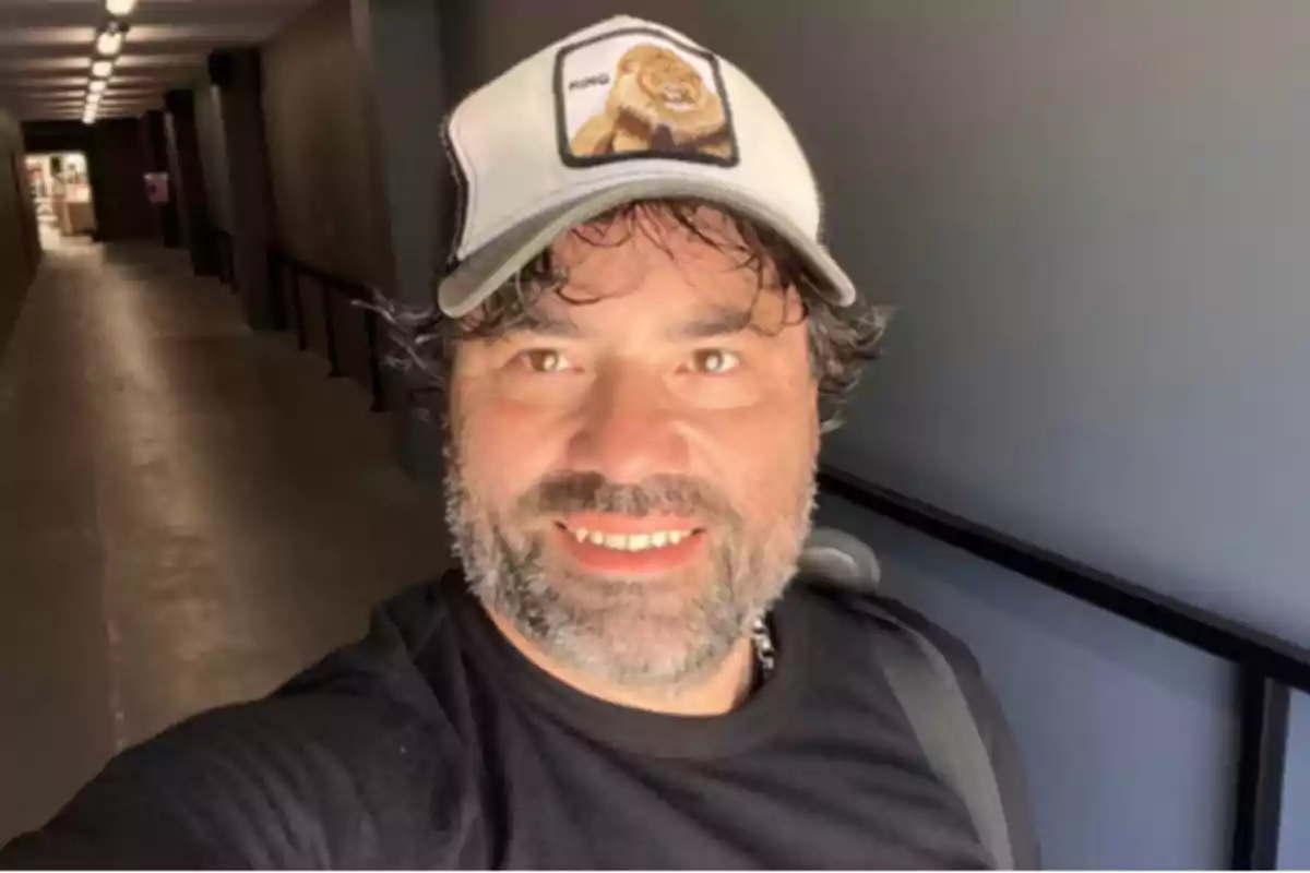 Bearded man wearing a cap smiles while taking a selfie in a brightly lit hallway Bearded man wearing a cap smiles while taking a selfie in a brightly lit hallway