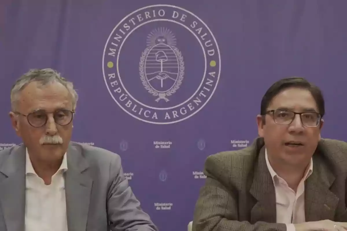 Dos hombres sentados frente a un fondo violeta con el logo del Ministerio de Salud de la República Argentina Dos hombres sentados frente a un fondo violeta con el logo del Ministerio de Salud de la República Argentina