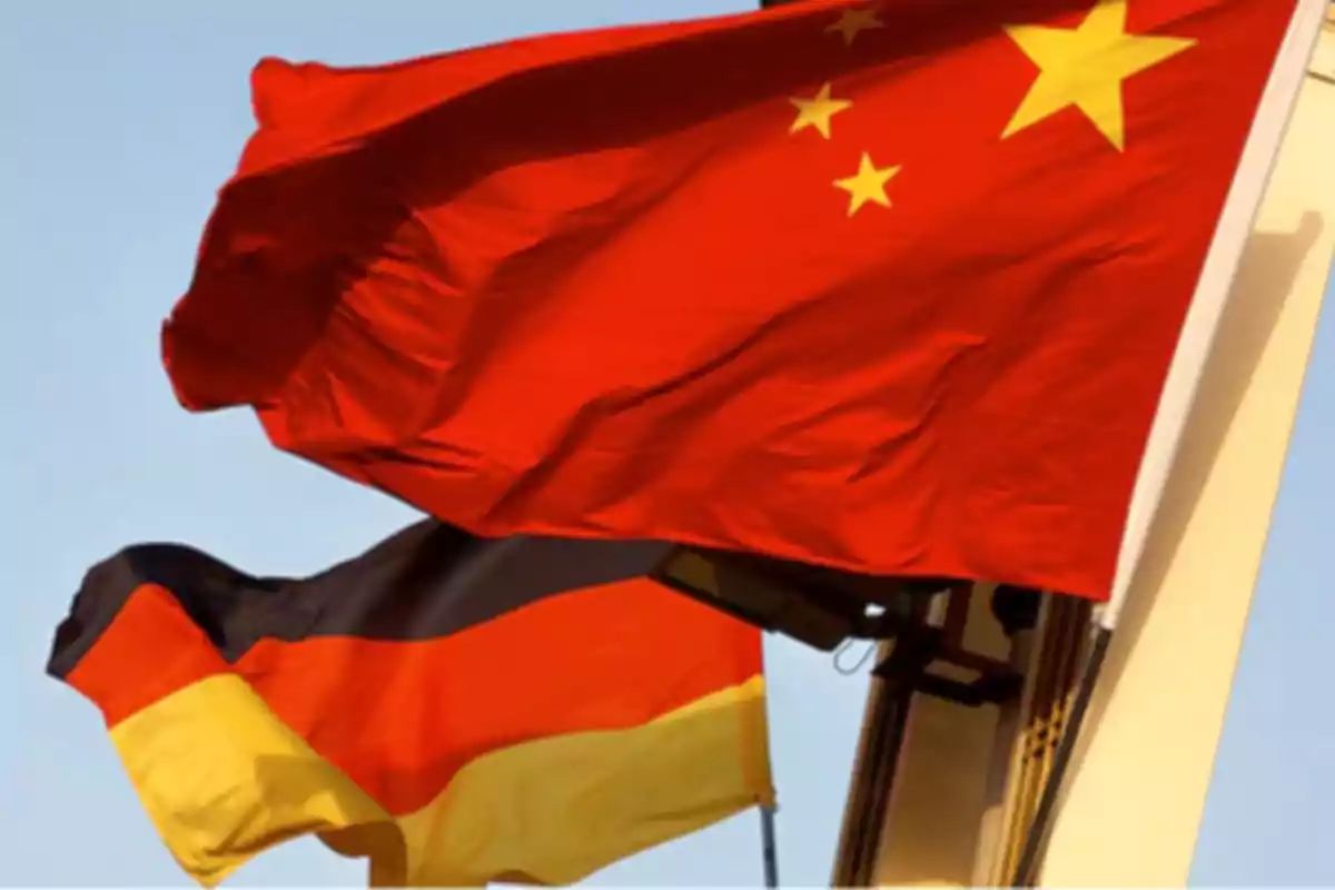 Banderas de China y Alemania ondeando juntas en un mástil bajo el cielo azul Banderas de China y Alemania ondeando juntas en un mástil bajo el cielo azul