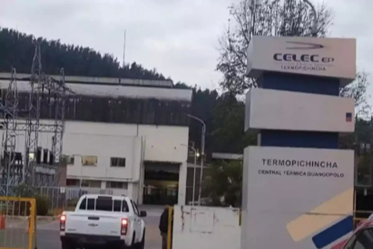 Main entrance of the Guangopolo Termopichincha thermal power plant with a CELEC EP sign and a white pickup truck parked in front of the industrial building Main entrance of the Guangopolo Termopichincha thermal power plant with a CELEC EP sign and a white pickup truck parked in front of the industrial building