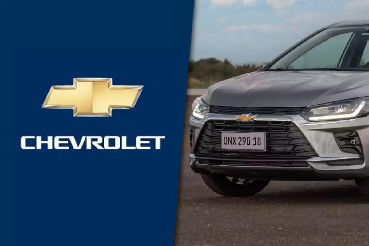 Logo de Chevrolet junto a la parte frontal de un automóvil gris de la misma marca estacionado en exterior.