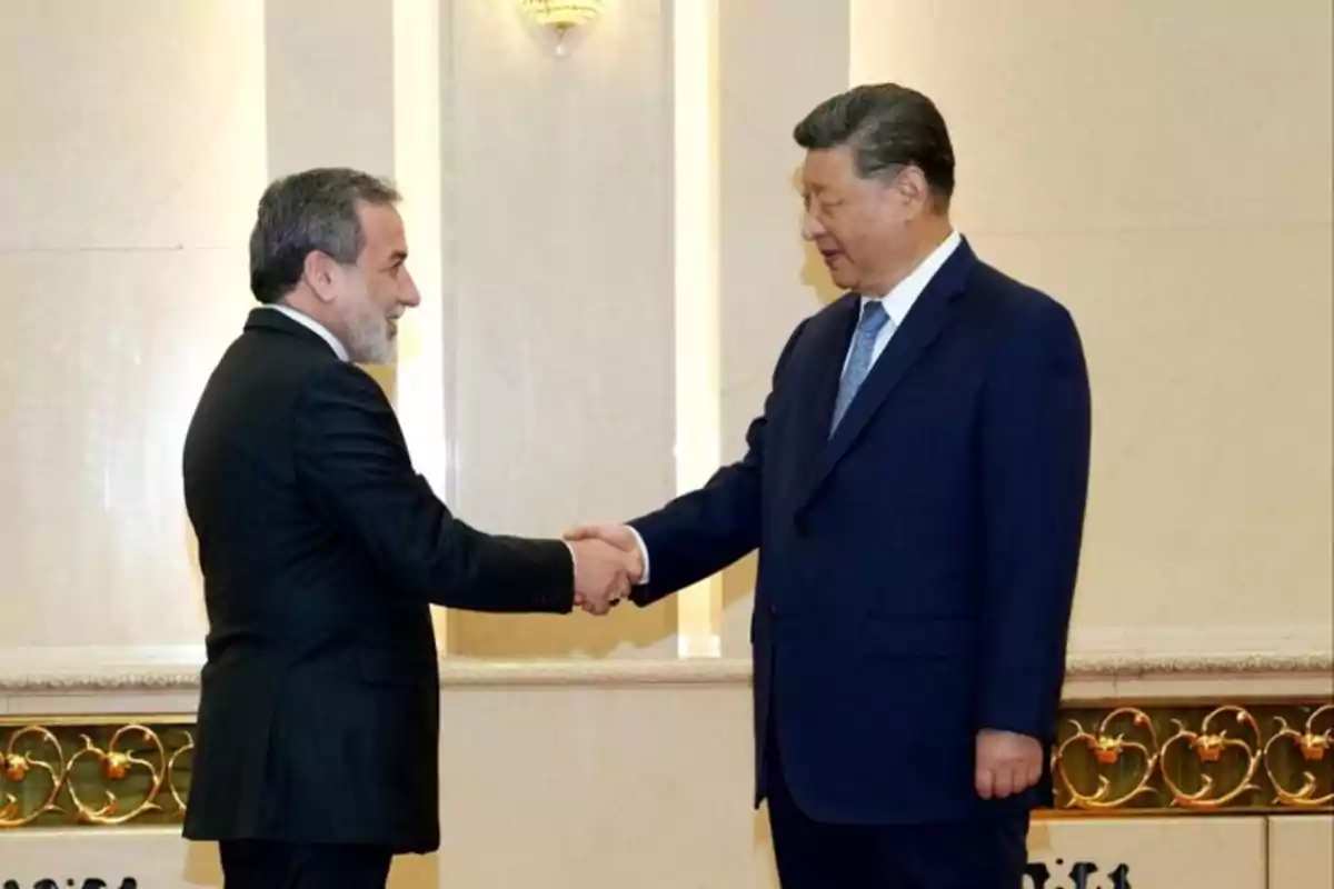 Two men in suits shake hands in a formal and elegant setting.