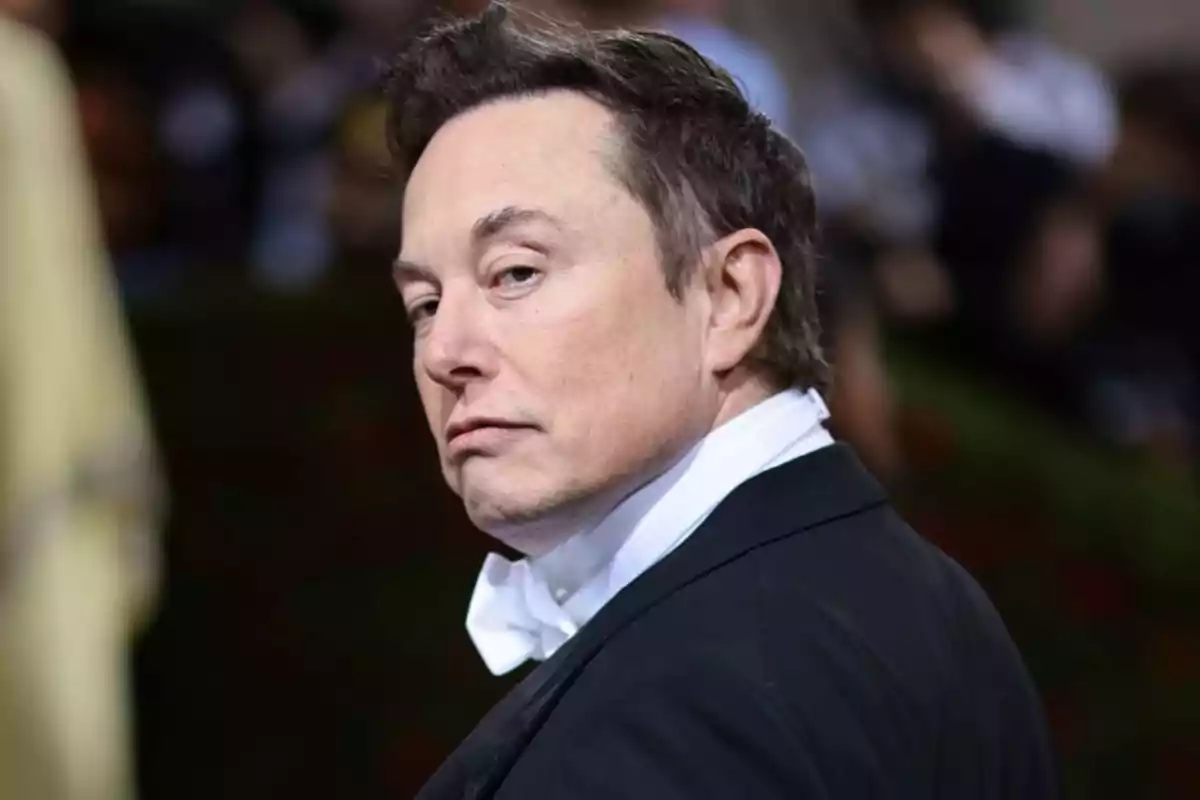 Man in a black tuxedo and white bow tie looking over his shoulder at an elegant event Man in a black tuxedo and white bow tie looking over his shoulder at an elegant event