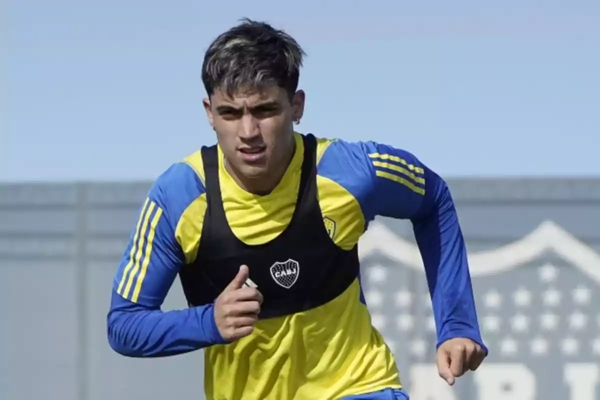 Jugador de fútbol entrenando con camiseta azul y amarilla de Boca Juniors en una cancha al aire libre