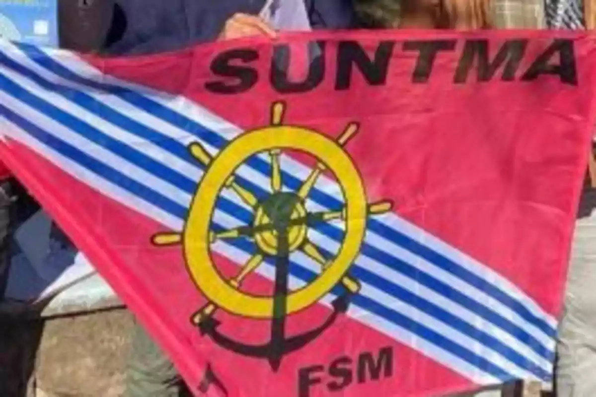 Bandera roja con franjas diagonales azules y blancas, un timón amarillo y un ancla negro en el centro, y las siglas SUNTMA y FSM en negro. Bandera roja con franjas diagonales azules y blancas, un timón amarillo y un ancla negro en el centro, y las siglas SUNTMA y FSM en negro.
