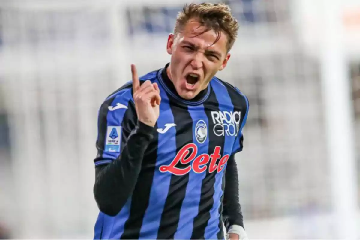 Futbolista celebrando un gol con el uniforme azul y negro del Atalanta, levantando un dedo y mostrando una expresión de emoción Futbolista celebrando un gol con el uniforme azul y negro del Atalanta, levantando un dedo y mostrando una expresión de emoción