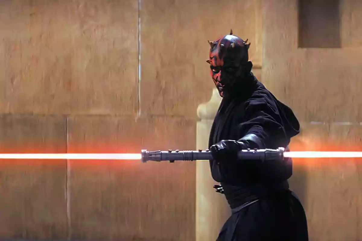 Warrior with a black robe and a double red lightsaber in a combat stance in front of a beige wall Warrior with a black robe and a double red lightsaber in a combat stance in front of a beige wall