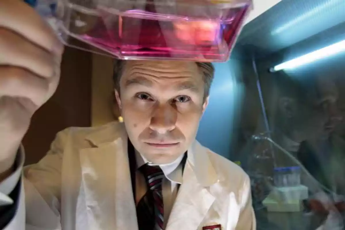 Scientist in a white lab coat observes a container with pink liquid in a brightly lit laboratory Scientist in a white lab coat observes a container with pink liquid in a brightly lit laboratory