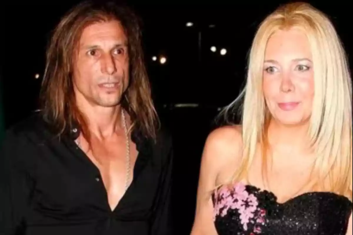 Una pareja posando de noche, el hombre lleva camisa negra y la mujer un vestido negro con detalles rosas Una pareja posando de noche, el hombre lleva camisa negra y la mujer un vestido negro con detalles rosas