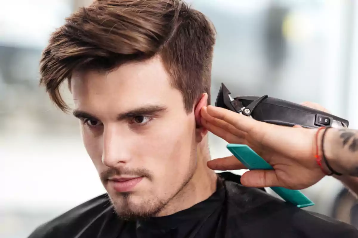 Hombre joven recibiendo un corte de cabello con máquina en una barbería