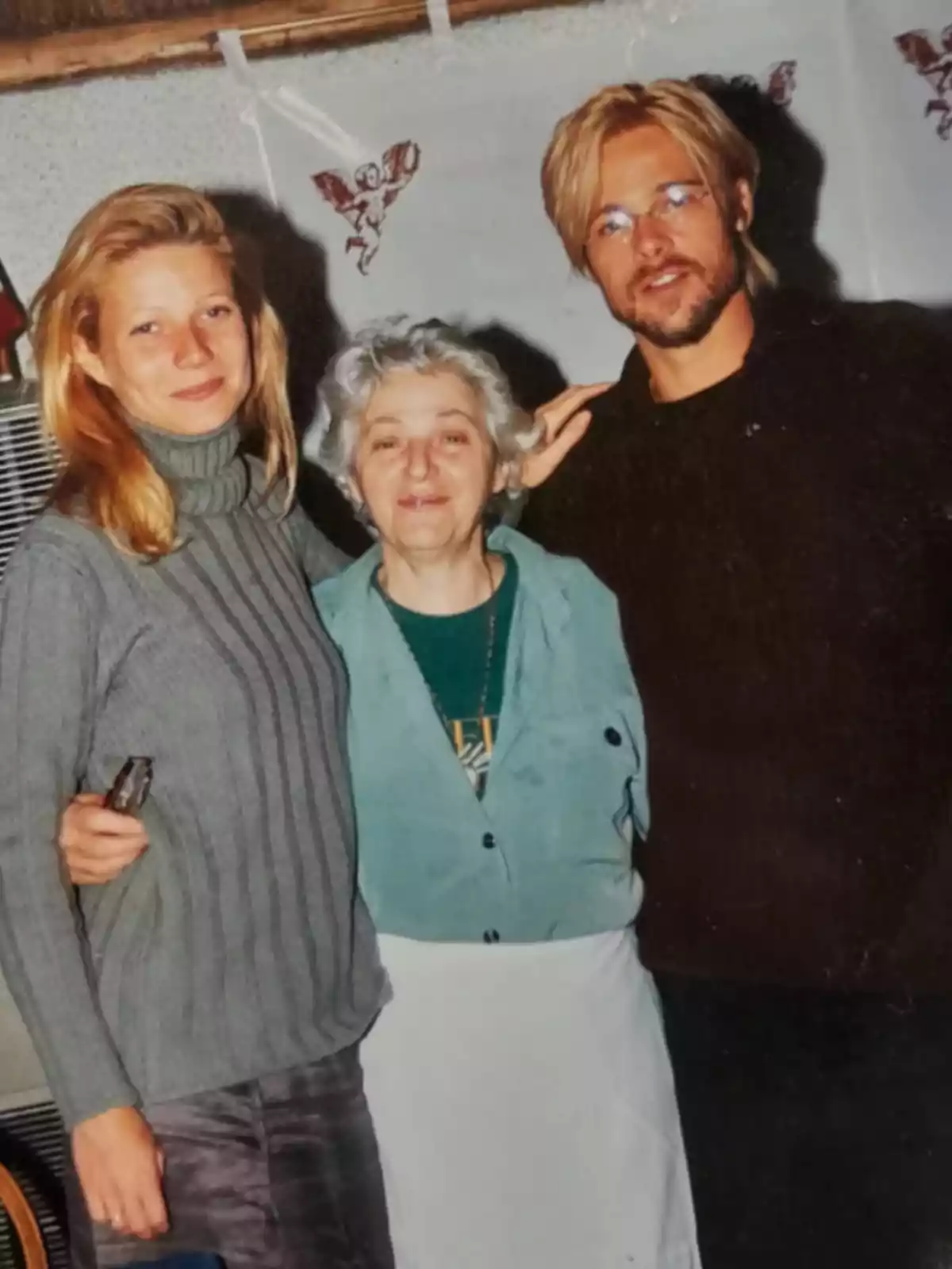 Three people pose together and smile for a photo in an indoor setting. Three people pose together and smile for a photo in an indoor setting.
