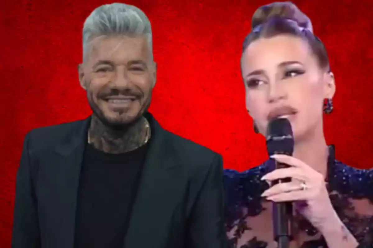A gray-haired, bearded man smiles while a woman with her hair up holds a microphone against a red background.
