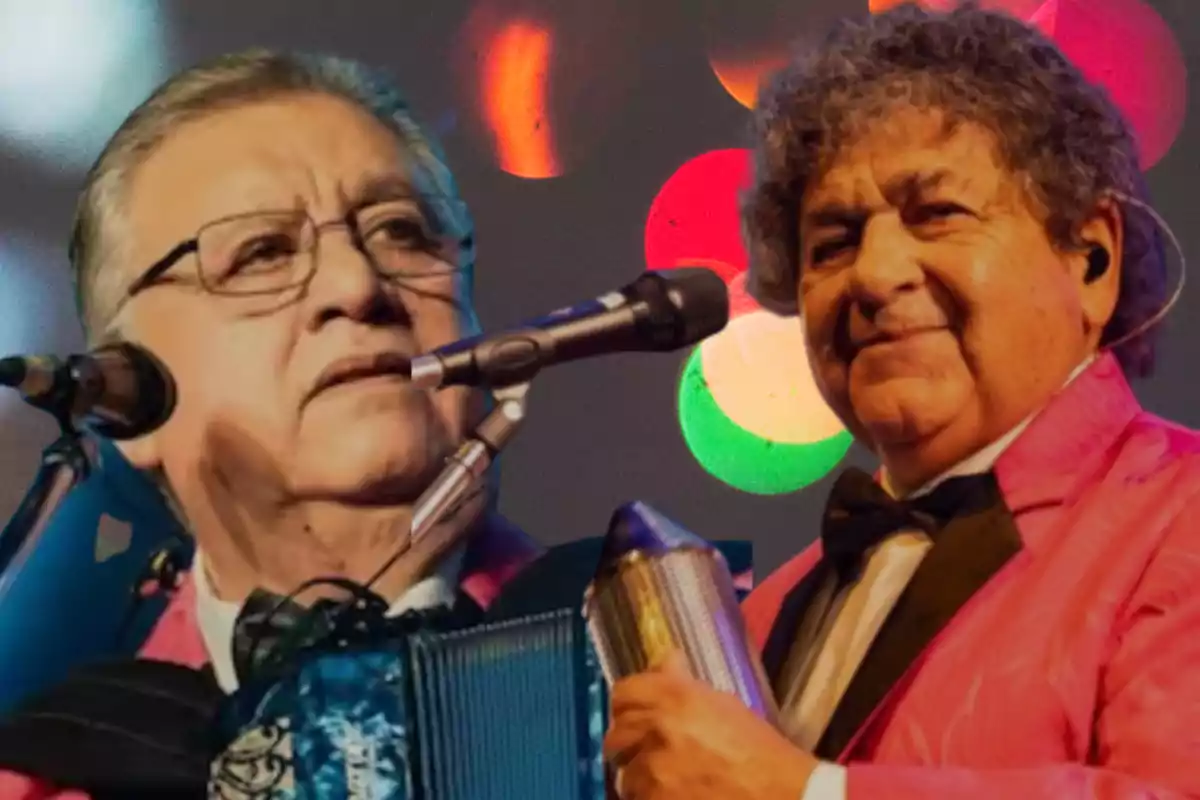 Two musicians in pink suits and white jerseys, one playing the accordion and the other the güiro, both in front of microphones with blurred colored lights in the background.