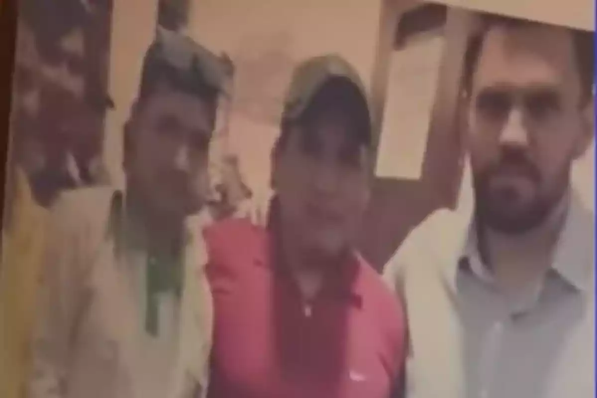 Cuatro personas posan juntas en una fotografía de ambiente interior con luz cálida, la imagen está algo borrosa. Cuatro personas posan juntas en una fotografía de ambiente interior con luz cálida, la imagen está algo borrosa.