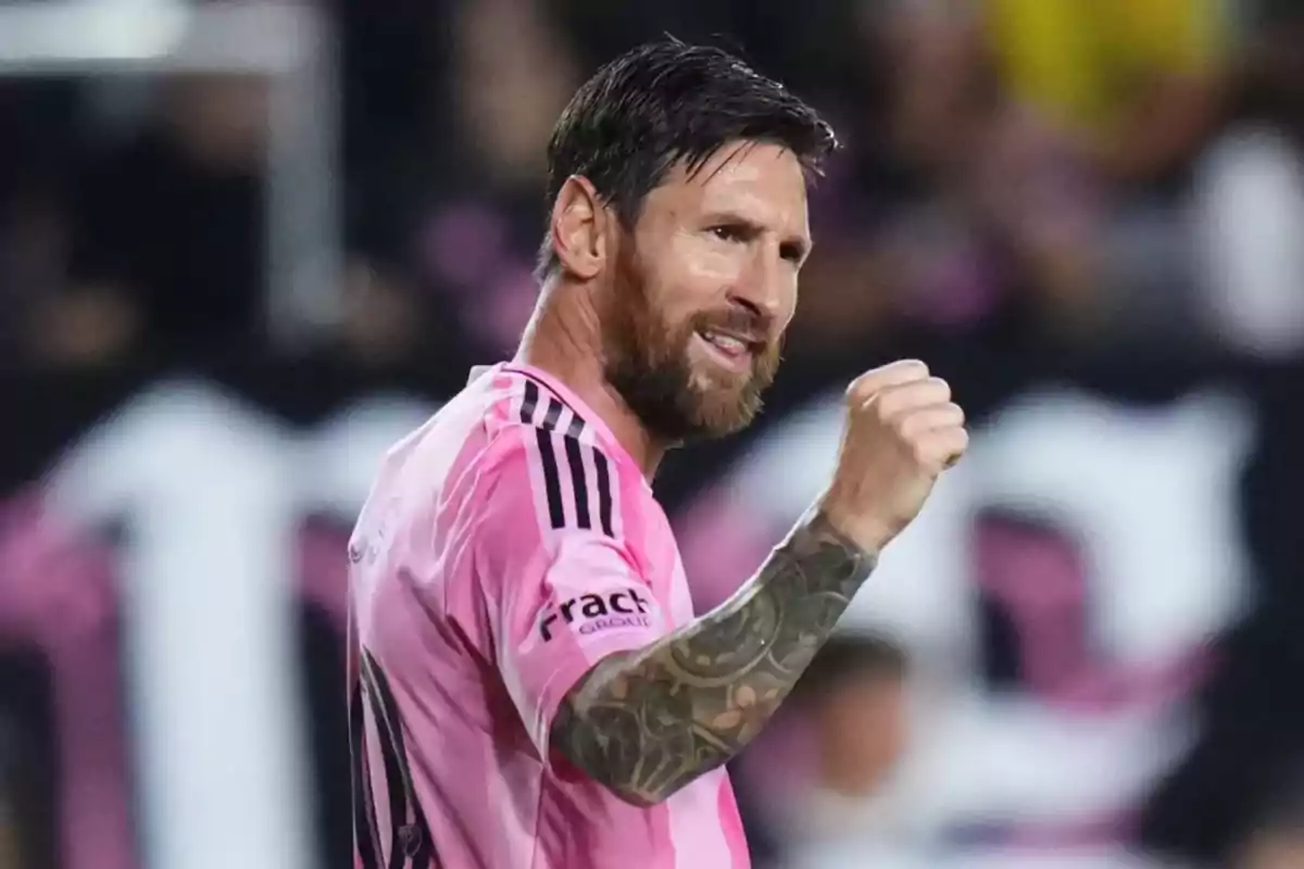 Futbolista con uniforme rosa celebrando con el puño en alto durante un partido