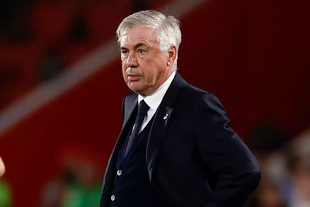 Gray-haired man in a dark suit in a sports setting Gray-haired man in a dark suit in a sports setting