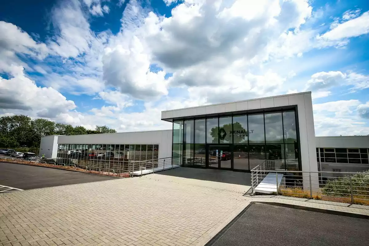 Modern Renault building with glass facade and partly cloudy sky Modern Renault building with glass facade and partly cloudy sky