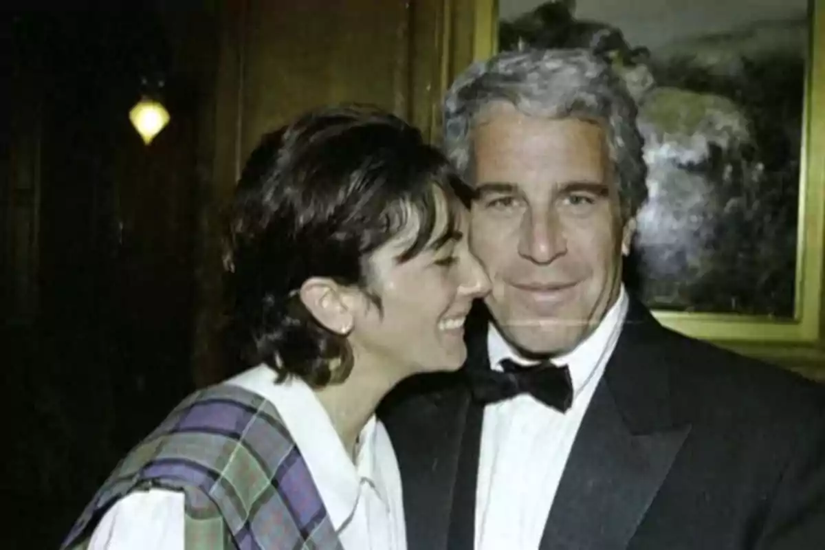 Dos personas posan juntas en un evento formal, una de ellas sonríe mientras la otra mira a la cámara con expresión seria Dos personas posan juntas en un evento formal, una de ellas sonríe mientras la otra mira a la cámara con expresión seria