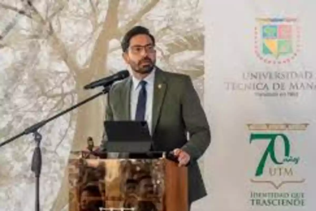 Man with glasses and a beard speaking at a podium with a microphone at a Technical University of Manabí event Man with glasses and a beard speaking at a podium with a microphone at a Technical University of Manabí event