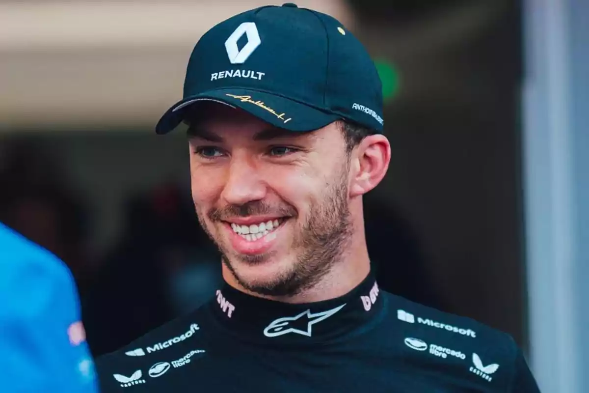 Piloto de automovilismo sonriendo con gorra y uniforme de Renault Piloto de automovilismo sonriendo con gorra y uniforme de Renault