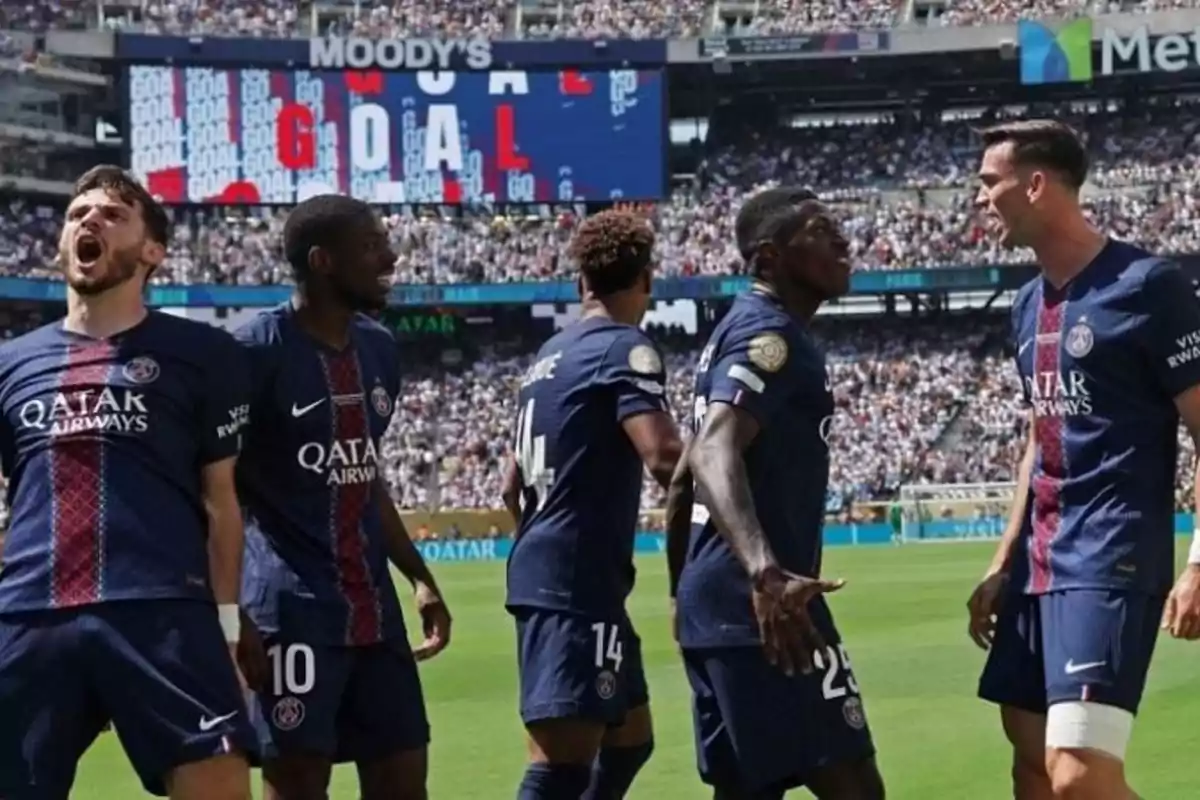 Jugadores del PSG celebran un gol en el estadio frente a una multitud mientras en la pantalla se lee la palabra GOAL Jugadores del PSG celebran un gol en el estadio frente a una multitud mientras en la pantalla se lee la palabra GOAL