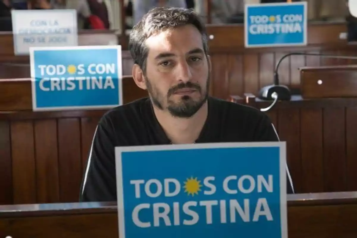 Man sitting in a room with blue signs that say Man sitting in a room with blue signs that say
