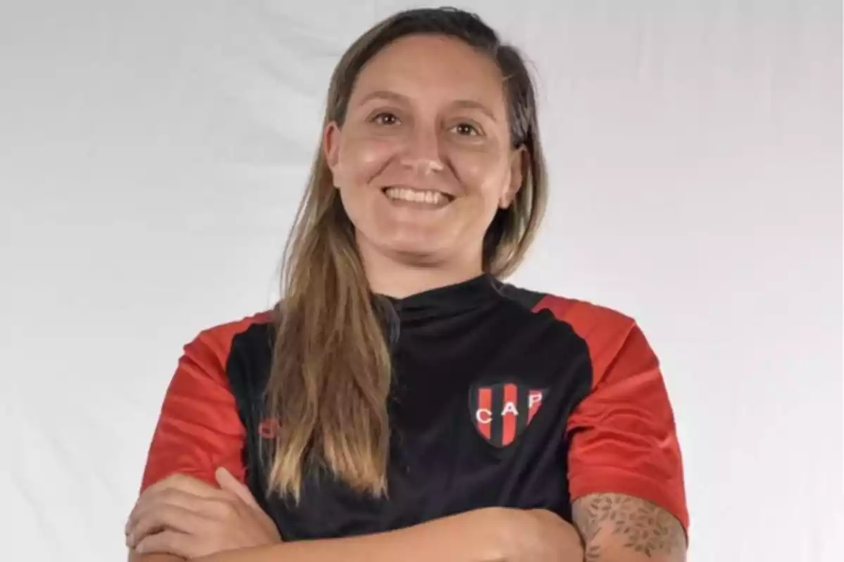 Smiling woman wearing a black and red sports jersey with the CAP crest and a light background Smiling woman wearing a black and red sports jersey with the CAP crest and a light background
